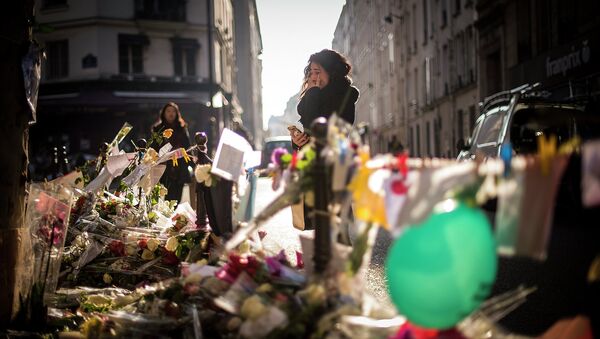 Девушка у импровизированного мемориала жертвам погибших в терактах в Париже. Архивное фото