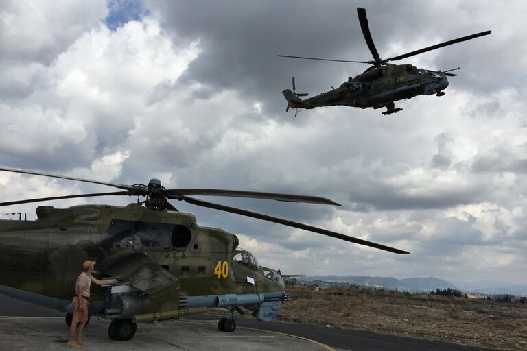 Техник у российского ударного вертолета МИ-24 на аэродроме Хмеймим в Сирии