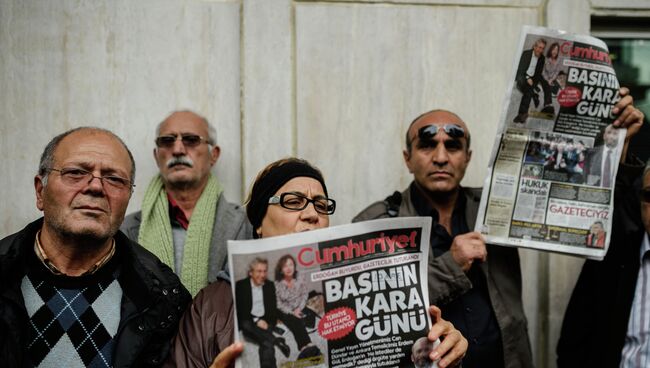 Люди держат выпуск газеты газеты Cumhuriyet возле здания редакции. Архивное фото