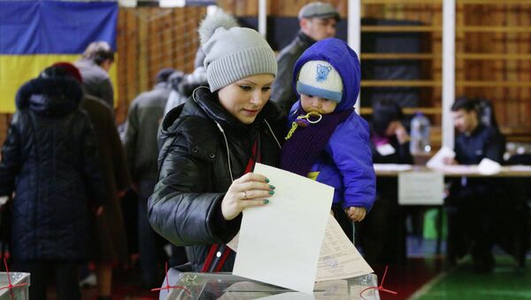 Женщина с ребенком на избирательном участке в Мариуполе