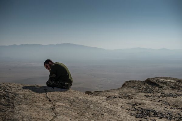 Боец из подразделений Сирийского народного ополчения около наблюдательного пункта в 20 км к западу от Пальмиры