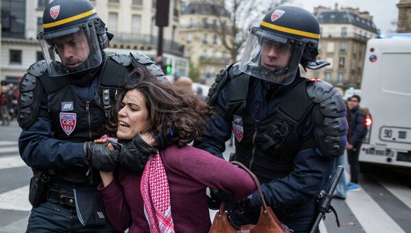 Полицейские задерживают участницу протестных экологических акций в Париже