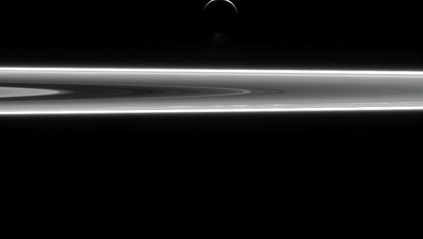 Изображение колец Сатурна и спутника Энцелада сделано Кассини