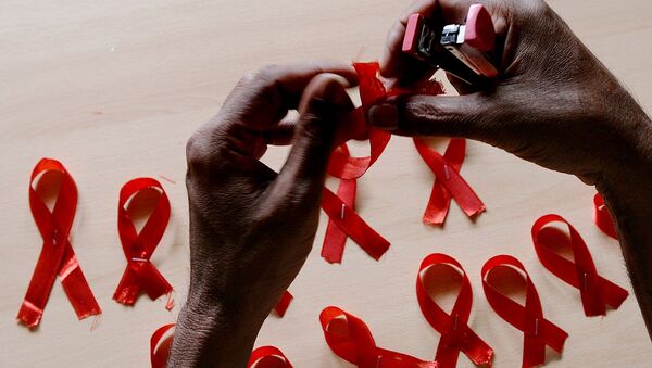 Мужчина делает красные ленточки, символ борьбы со СПИДом. Архивное фото