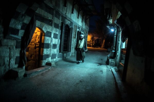 Мужчина идёт по одной из улиц в старом городе в Дамаске