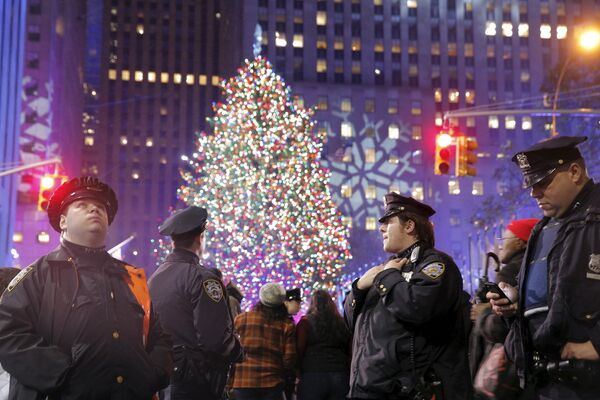 Офицеры полиции Нью-Йорка во время церемонии зажжения огней главной рождественской елки у небоскреба Рокфеллер-центра в Нью-Йорке, США