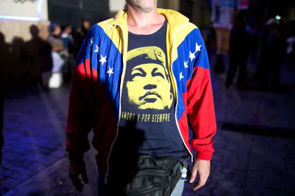 Сторонник правящей партии с портретом Уго Чавеса на футболке в ожидании результатов голосования на парламентских выборах в Каракасе, Венесуэла