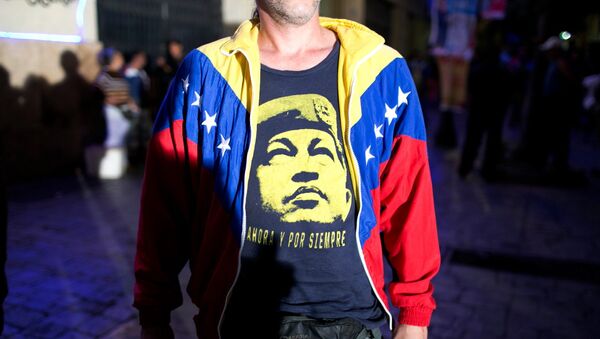 Сторонник правящей партии Венесуэлы с портретом Уго Чавеса, архивное фото