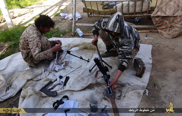 Боевики ИГ (ДАИШ) чистят оружие в городе Дайр-эз-Заур, Сирия