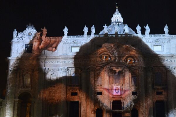 Фотопроекция на фасаде и куполе Базилики Святого Петра в Ватикане во время светового шоу Fiat Lux, осветим наш общий дом