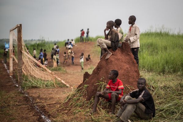 Дети наблюдают за футбольным матчем в лагере беженцев в Демократической республике Конго