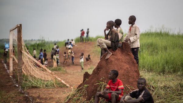 Дети наблюдают за футбольным матчем в лагере беженцев в Демократической республике Конго