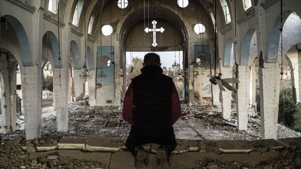Житель одной из сирийских молится в храме, уничтоженном боевиками ИГ. Архивное фото