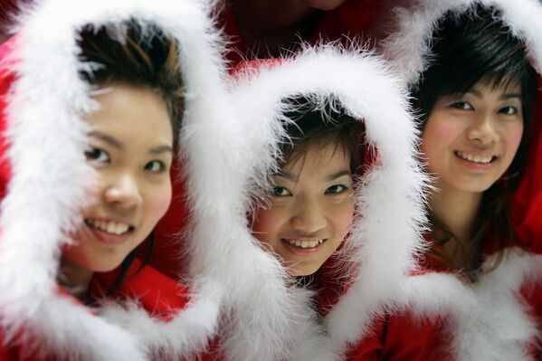 Девушки в костюмах Санта-Клаусов в торговом центре в Гонконге