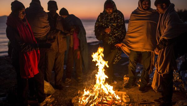 Мигранты греются у костра на греческом острове Лесбос