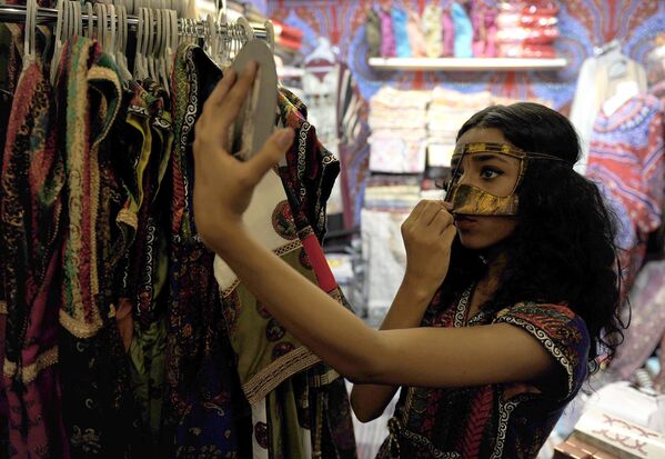 Саудовская девушка примеряет маску в магазине