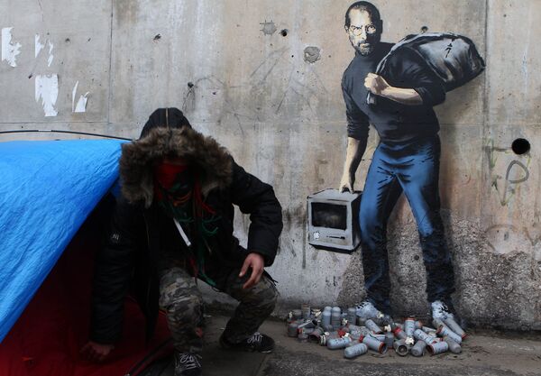 Граффити Бэнкси на стене лагеря для беженцев, в котором он изобразил Стива Джобса в роли мигранта