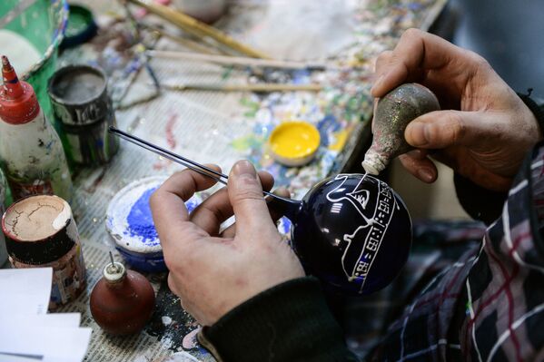 Художник расписывает елочные игрушки на предприятии Шаг за шагом в поселке Крестцы Новгородской области