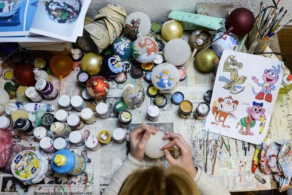 Художник расписывает ёлочные игрушки на предприятии Шаг за шагом в поселке Крестцы Новгородской области
