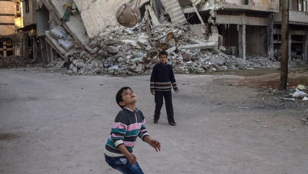 Дети играют в мяч в разрушенном районе Хомса аль Хамидия. Архивное фото