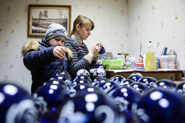 Художник расписывает ёлочные игрушки на предприятии Шаг за шагом в поселке Крестцы Новгородской области