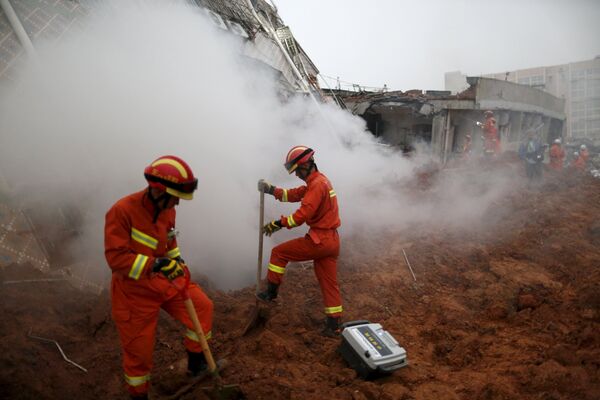 Пожарные работают на месте оползня в Китае, 20 декабря 2015