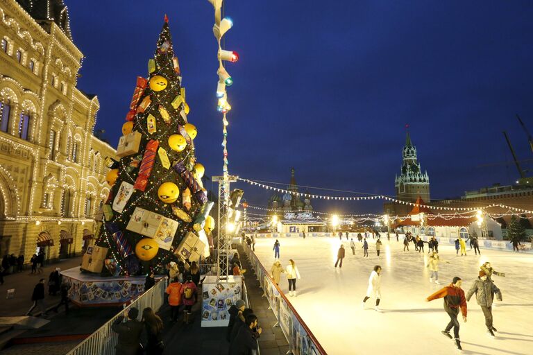 Люди катаются возле елки на Красной площади в Москве