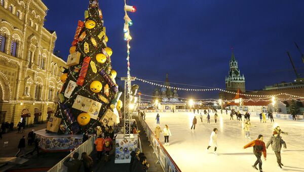 Люди катаются возле елки на Красной площади в Москве