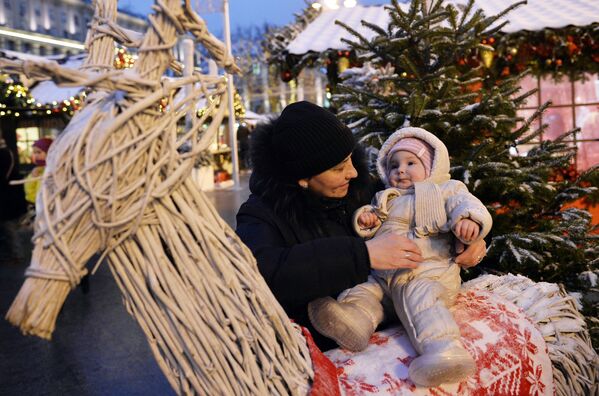 Женщина с ребенком на Рождественской ярмарке в рамках фестиваля Путешествие в Рождество в Москве