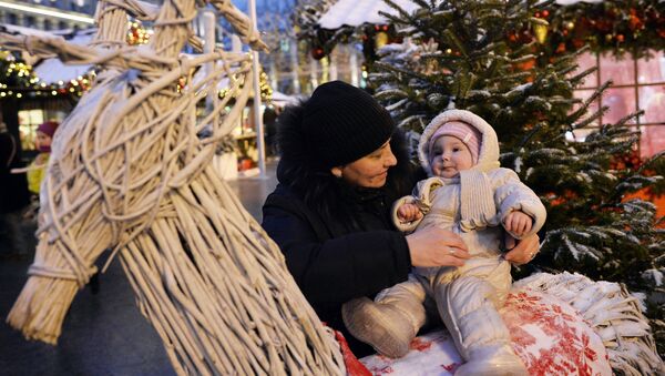 Женщина с ребенком на Рождественской ярмарке в рамках фестиваля Путешествие в Рождество в Москве. Архивное фото