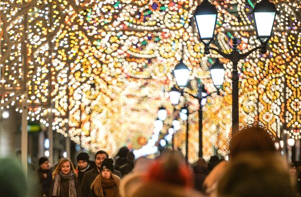 Прохожие на улице Никольская в Москве, где установлены световые инсталляции в рамках Международного фестиваля Рождественский свет