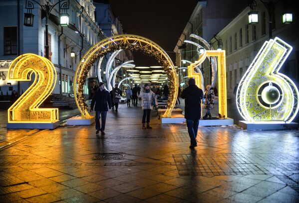 Прохожие на Рождественской ярмарке, где установлены световые инсталляции в рамках Международного фестиваля Рождественский свет в Камергерском переулке в Москве