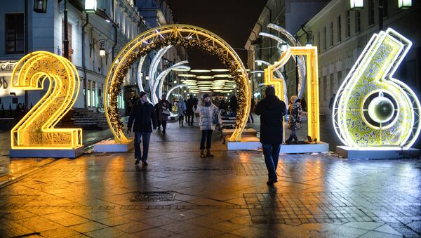 Прохожие на Рождественской ярмарке, где установлены световые инсталляции в рамках Международного фестиваля Рождественский свет в Камергерском переулке в Москве