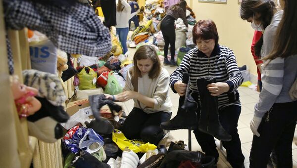 Жительница дома по улице Космонавтов, разрушенного в результате взрыва бытового газа, выбирает одежду на временном пункте приема жителей
