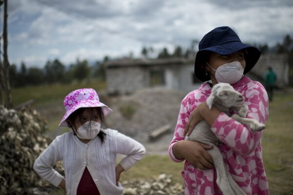 Дети в масках во время извержения вулкана Котопахи в Эквадоре