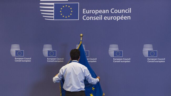 Служащий поправляет флаг в здании Совета Европы в Брюсселе. Архивное фото