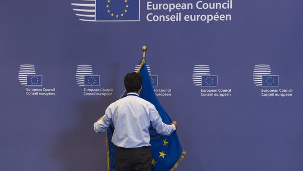 Служащий поправляет флаг в здании Совета Европы в Брюсселе, Бельгия