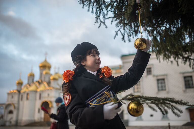 Кадет украшает Новогоднюю ёлку на Соборной площади Кремля в Москве