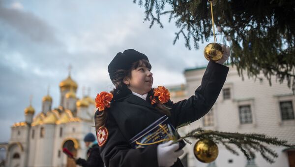 Кадет украшает Новогоднюю ёлку на Соборной площади Кремля в Москве