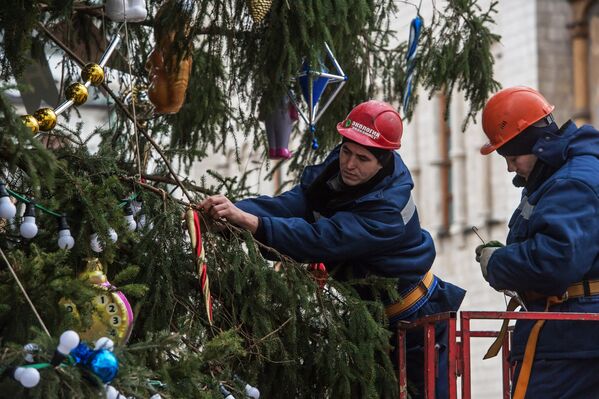 Рабочие украшают Новогоднюю елку на Соборной площади Кремля в Москве