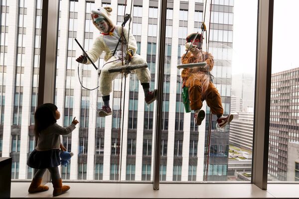 Мойщики стекол в костюме обезьяны и овцы в Токио