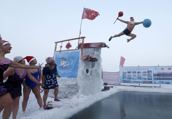 Мужчина в шапке Санта-Клауса прыгает в холодную воду в Китае