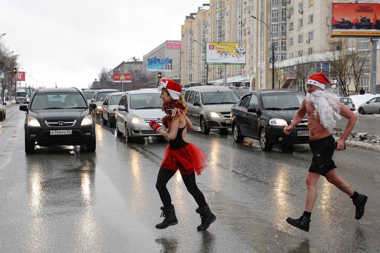 Участники клубов закаливания и зимнего плавания во время забега в костюмах дедов морозов