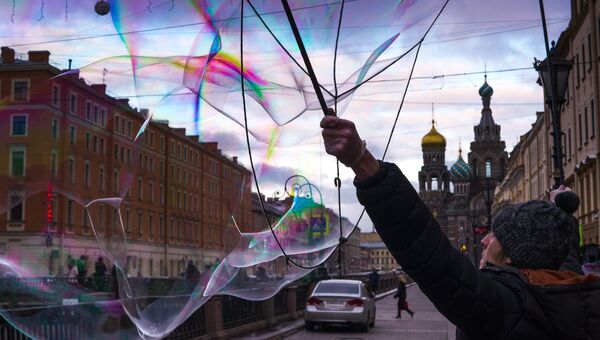 Уличный артист надувает мыльные пузыри. Архивное фото