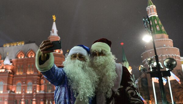Деды Морозы фотографируются во время празднования Нового года на Манежной площади в Москве