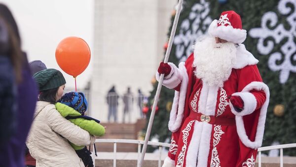 Аниматор в костюме Деда Мороза перед новогодней елкой на площади Ала-Тоо в Бишкеке