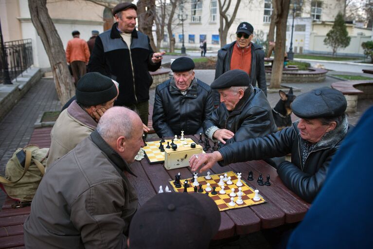 Мужчины играют в шахматы в Приморском парке Севастополя