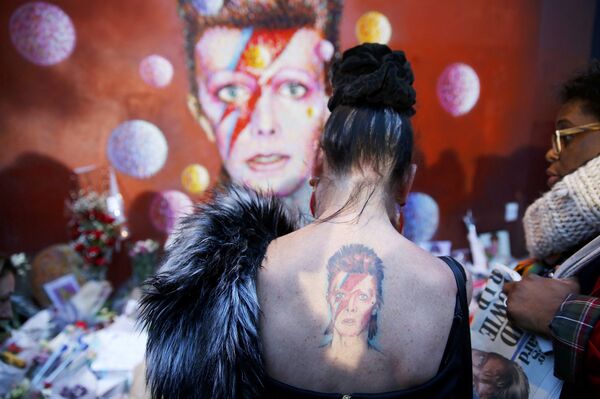 Женщина с татуировкой Ziggy Stardust у стены Дэвида Боуи в Брикстоне. Лондон, январь 2016