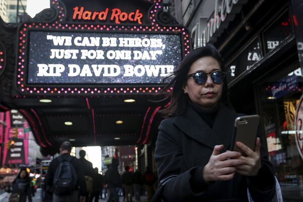 Женщина напротив Hard Rock Cafe на Таймс-сквер в Манхэттене. Нью-Йорк, январь 2016