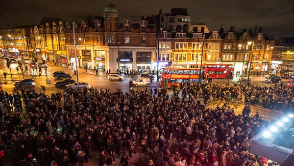 Поклонники на площади перед кинотеатром The Ritzy в Лондоне отдают дань уважения Дэвиду Боуи после известия о его смерти. Январь 2016